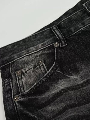 Men's black vintage wash wide leg jeans with distressed details.