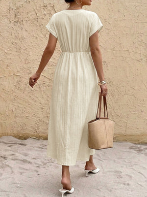Beige cotton blend midi dress with V-neck, short sleeves, elastic waist, and vertical texture.