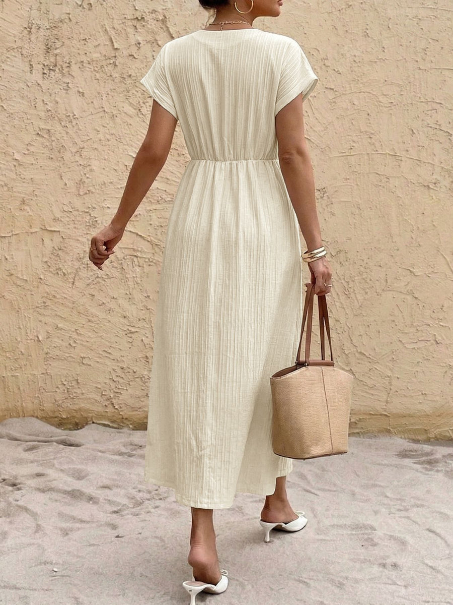 Beige cotton blend midi dress with V-neck, short sleeves, elastic waist, and vertical texture.