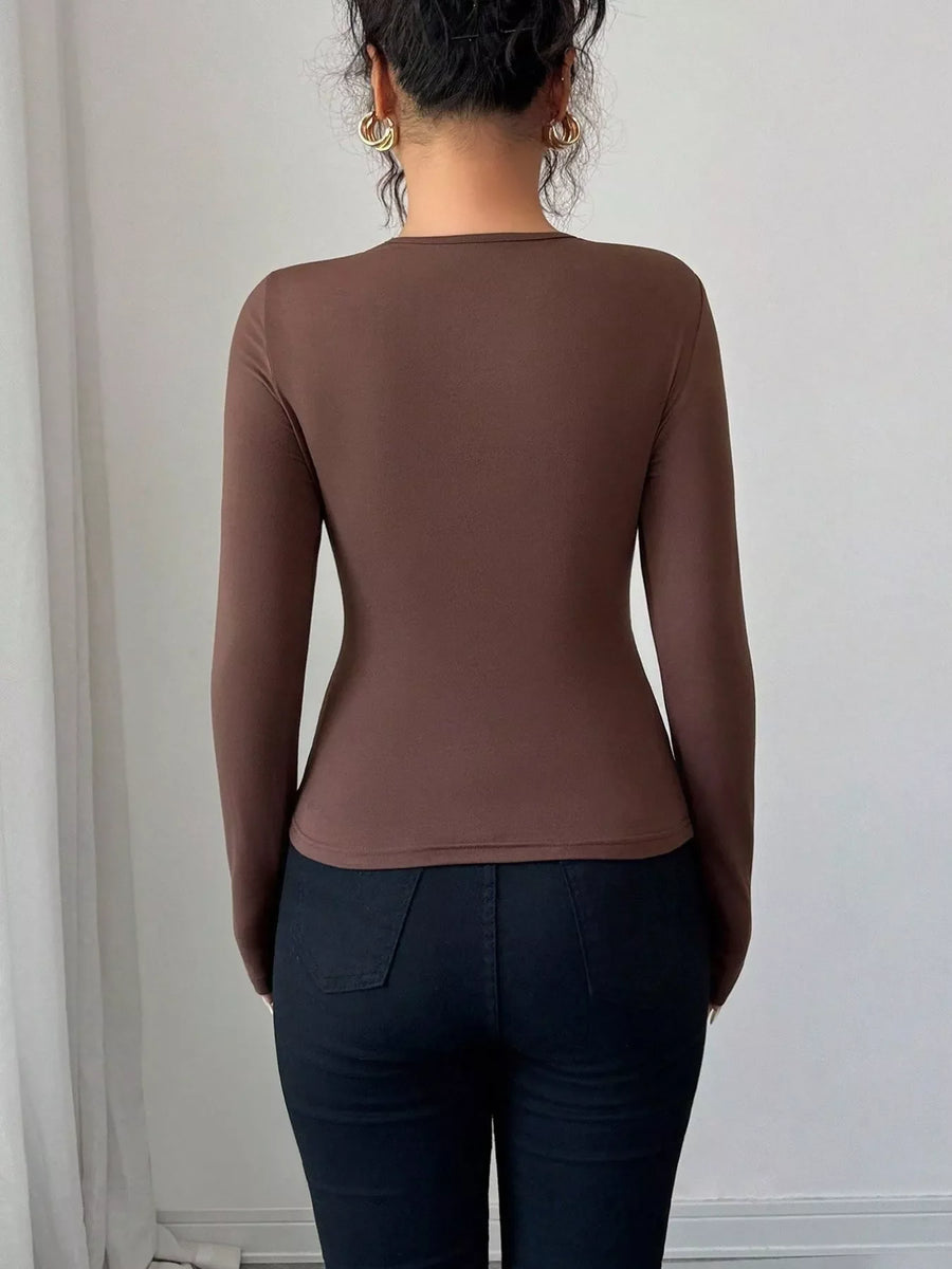 Brown long-sleeve tee with asymmetrical cutout detail.