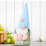 Bunny ear gnome decoration in green with pink Easter egg and blue knit hat with flower accent.
