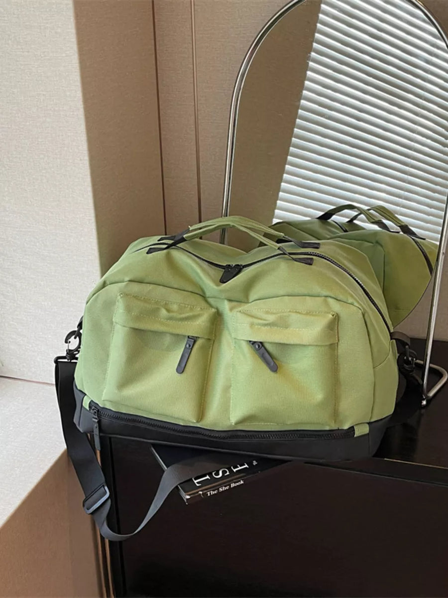 Green duffel bag with two front zip pockets and a black base.