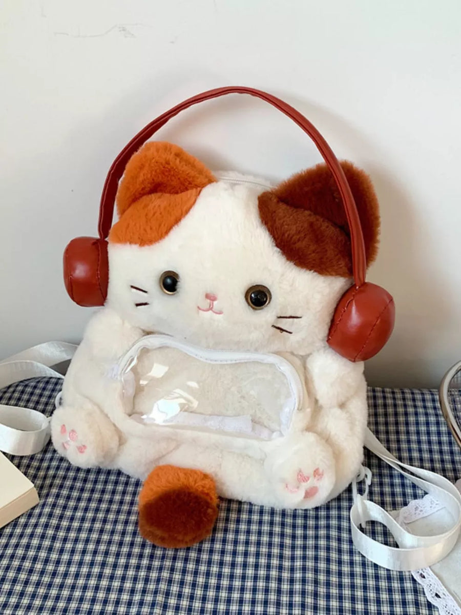 Mini plush cat backpack bag in white with orange and brown accents, featuring headphones and a clear pocket.