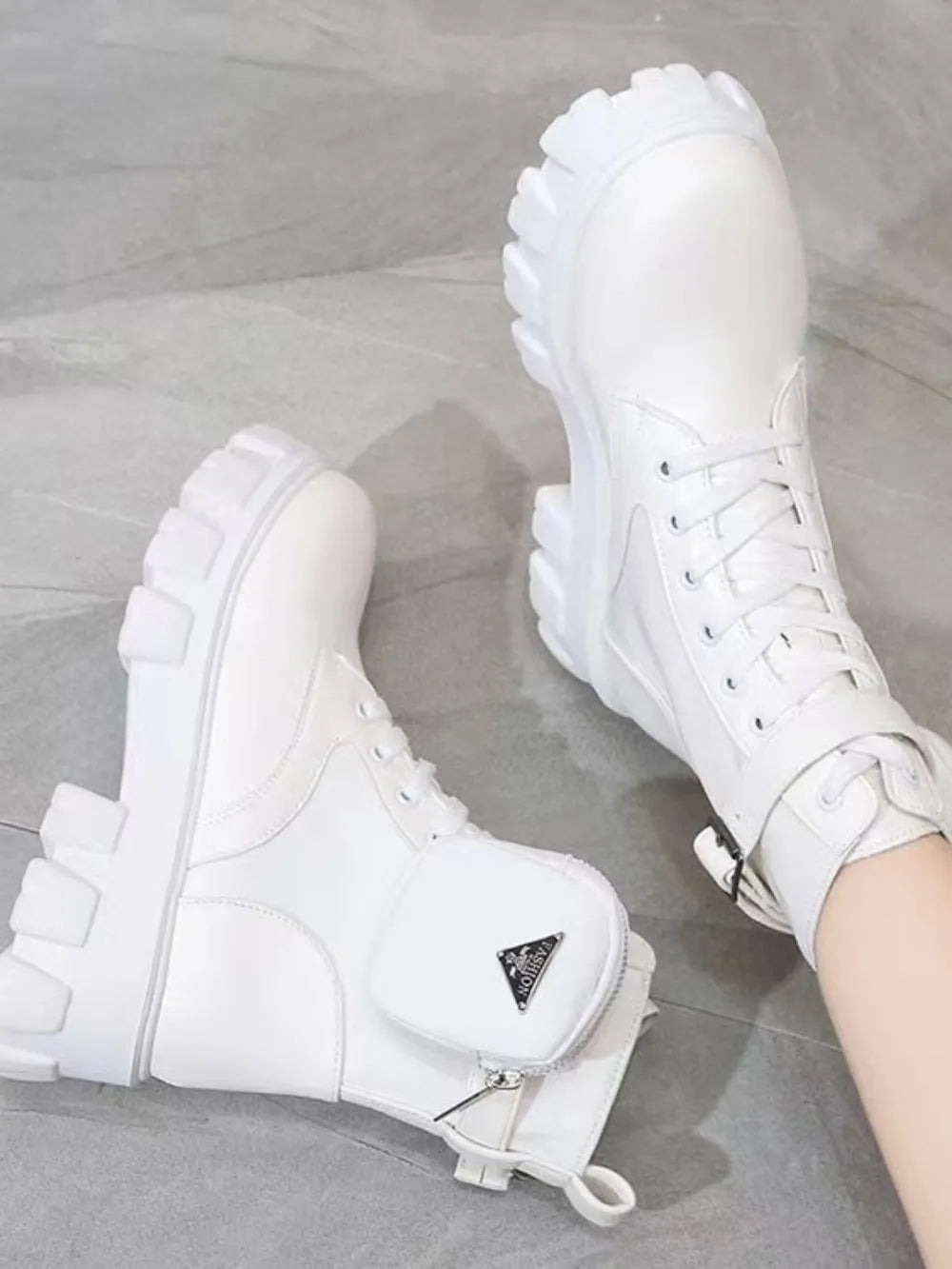 White utility pocket lug sole boots with lace-up front and buckle strap detail.