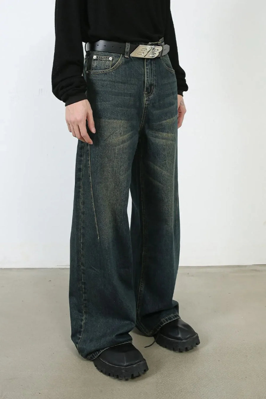 Faded dark denim wide-leg trousers with a relaxed fit and distressed details.