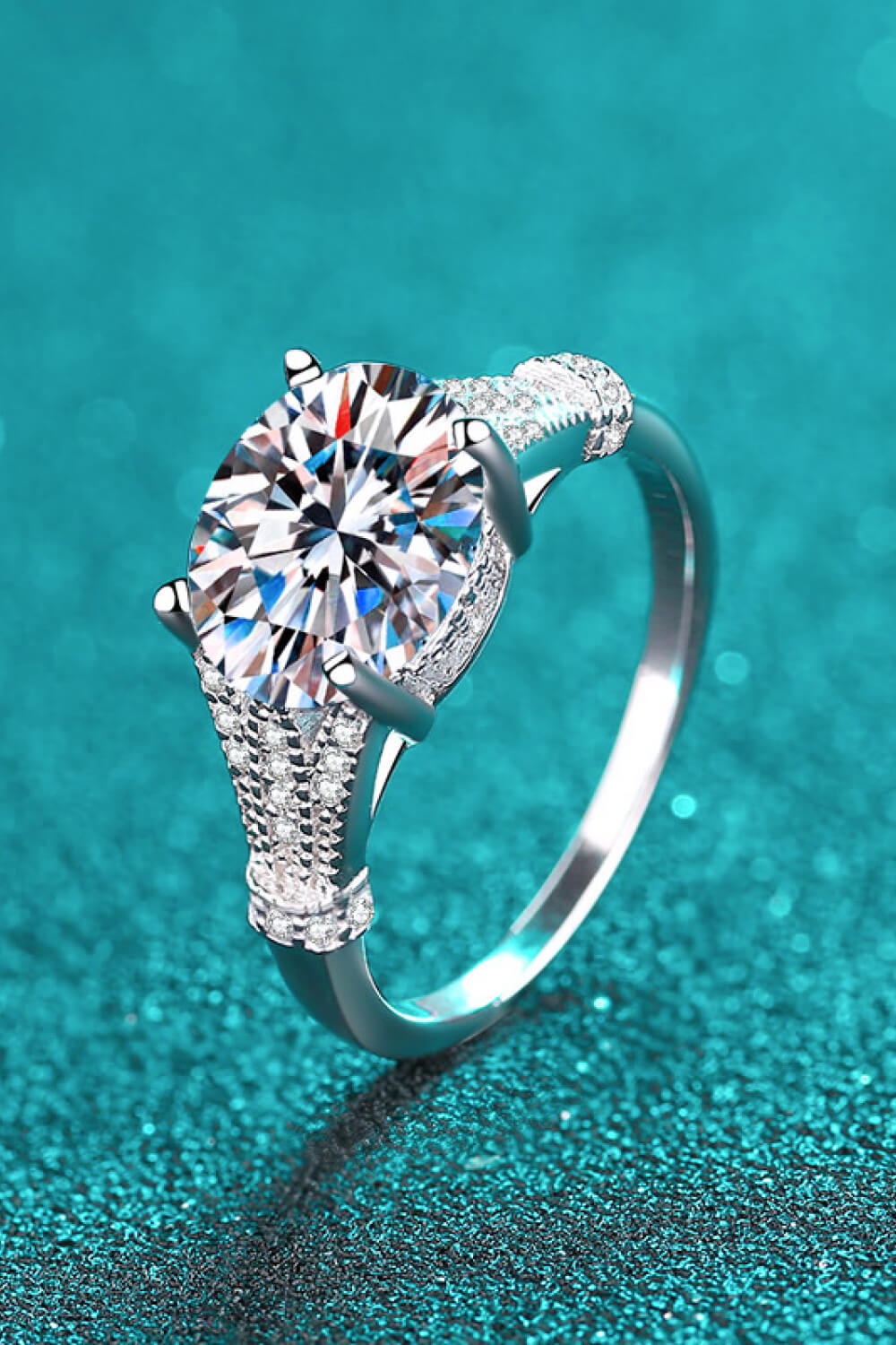 Silver pavé-set moissanite solitaire ring with intricate band details.