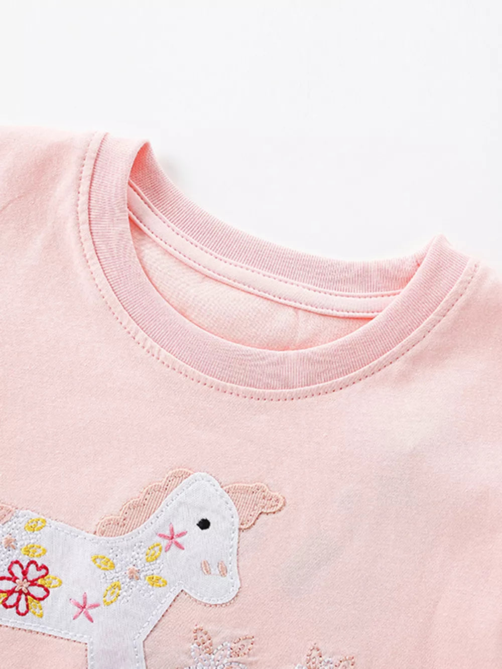 Pink cotton baby dress with embroidered unicorn and floral details.