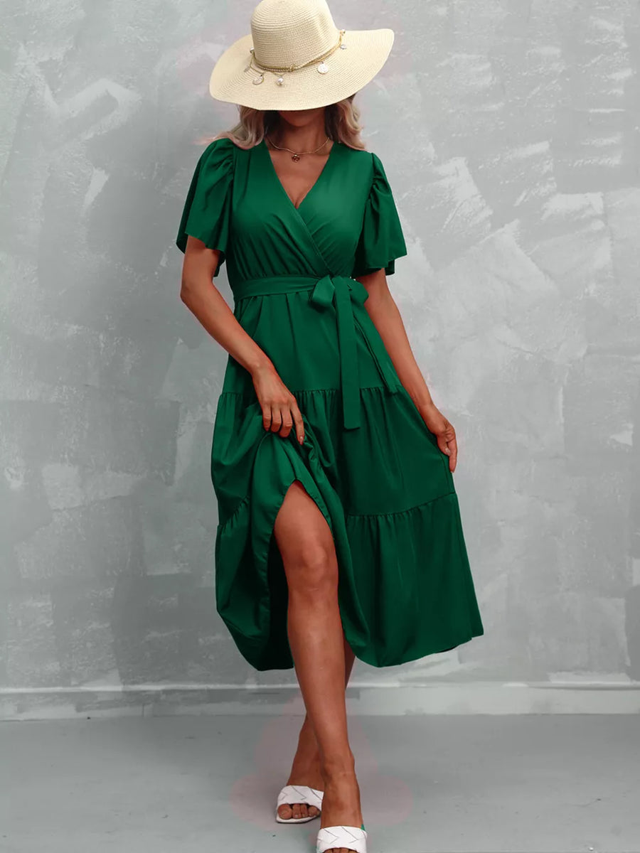 Dark green tiered midi dress with flutter sleeves, V-neck, and belted waist.
