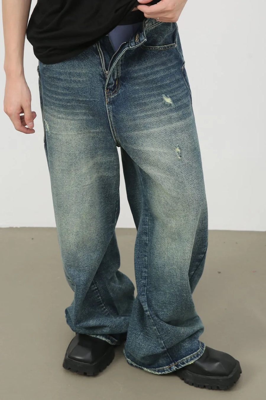 Distressed denim wide leg jeans for him in medium wash, featuring ripped details.