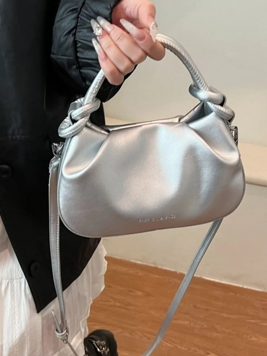 Mini ruched crossbody bag in silver with knotted handle and subtle logo detail.