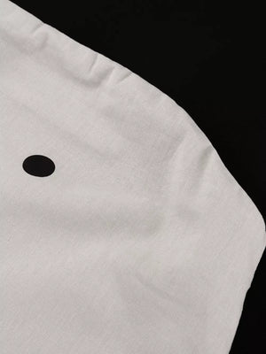 White linen shirt with a single black polka dot detail
