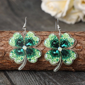Emerald clover earrings with dark green gemstones and acrylic material.