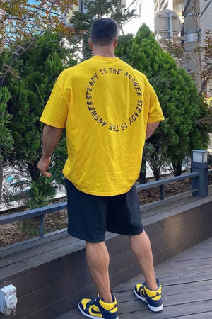 Yellow oversized t-shirt with black circular text graphic on back