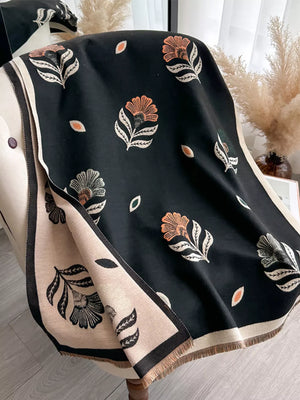 Black floral print fringed shawl with beige border and fringe detail.