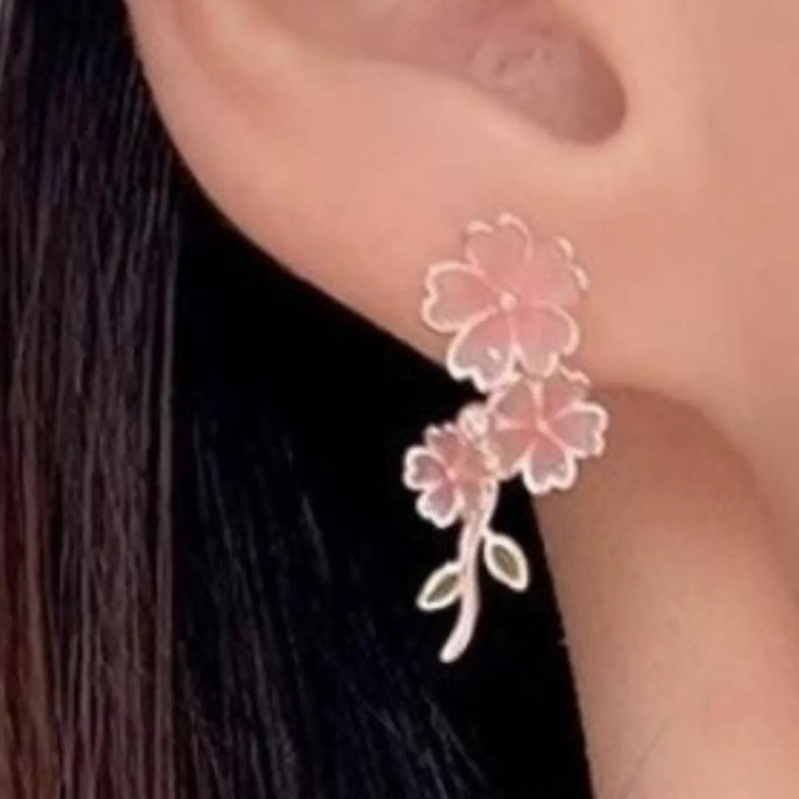 Blush pink floral drop earrings with asymmetrical design and leaf accents.