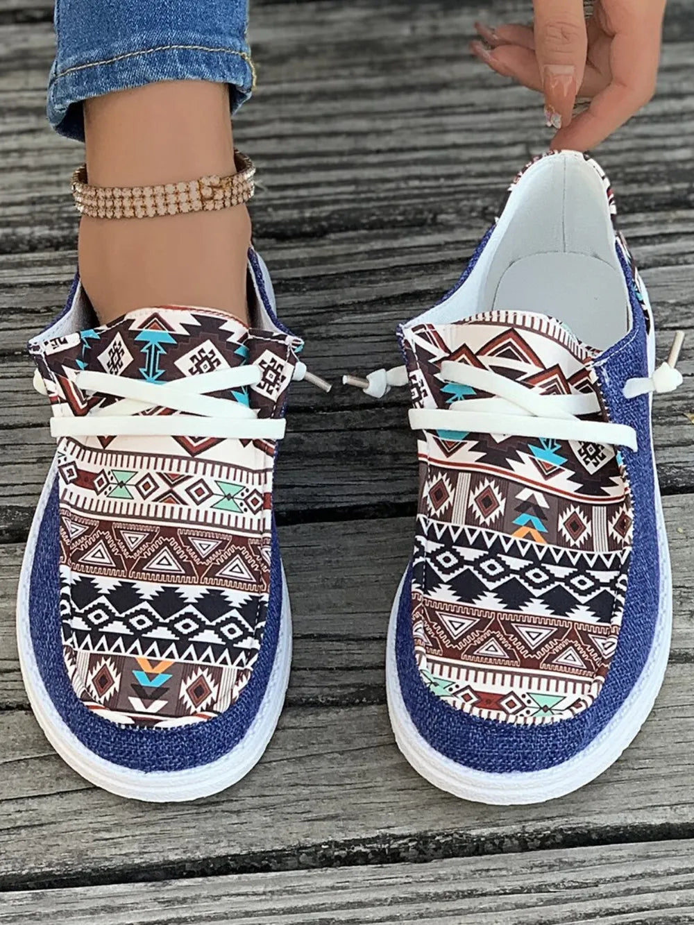 Aztec print canvas slip-on shoes in light indigo with white laces and a white sole.