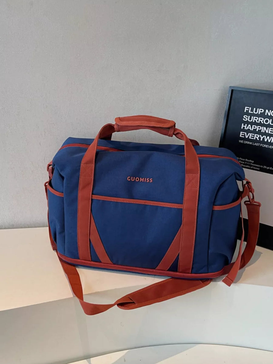 Blue duffel bag with red trim and straps, featuring "GUOMISS" logo.
