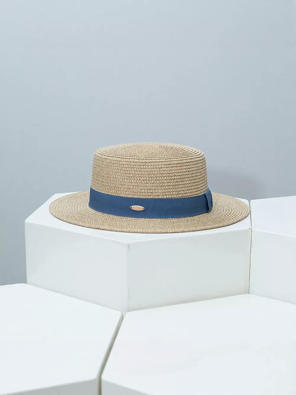 Straw boater hat with blue band and gold accent detail
