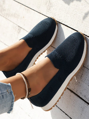 Dark navy breathable knit slip-on sneakers with white soles and a gum outsole.
