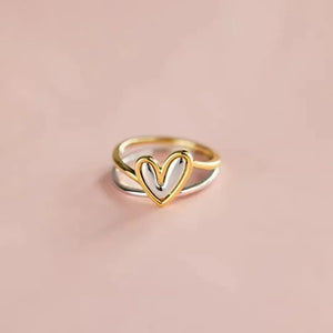 Two-tone heart outline ring with gold and silver bands.