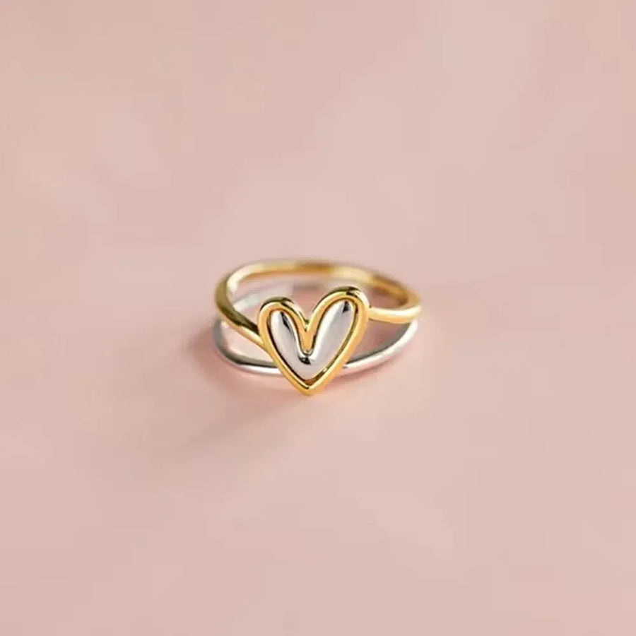 Two-tone heart outline ring with gold and silver bands.