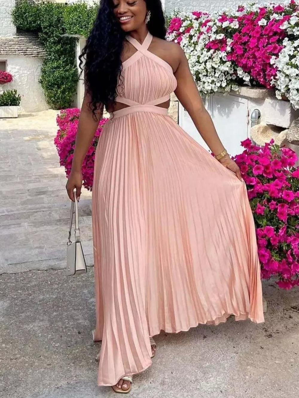 Peach pleated maxi dress with cutout detail and halter neckline.