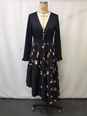 Elegant black maxi dress with floral print skirt, V-neck, decorative buttons, and ruffled hem.