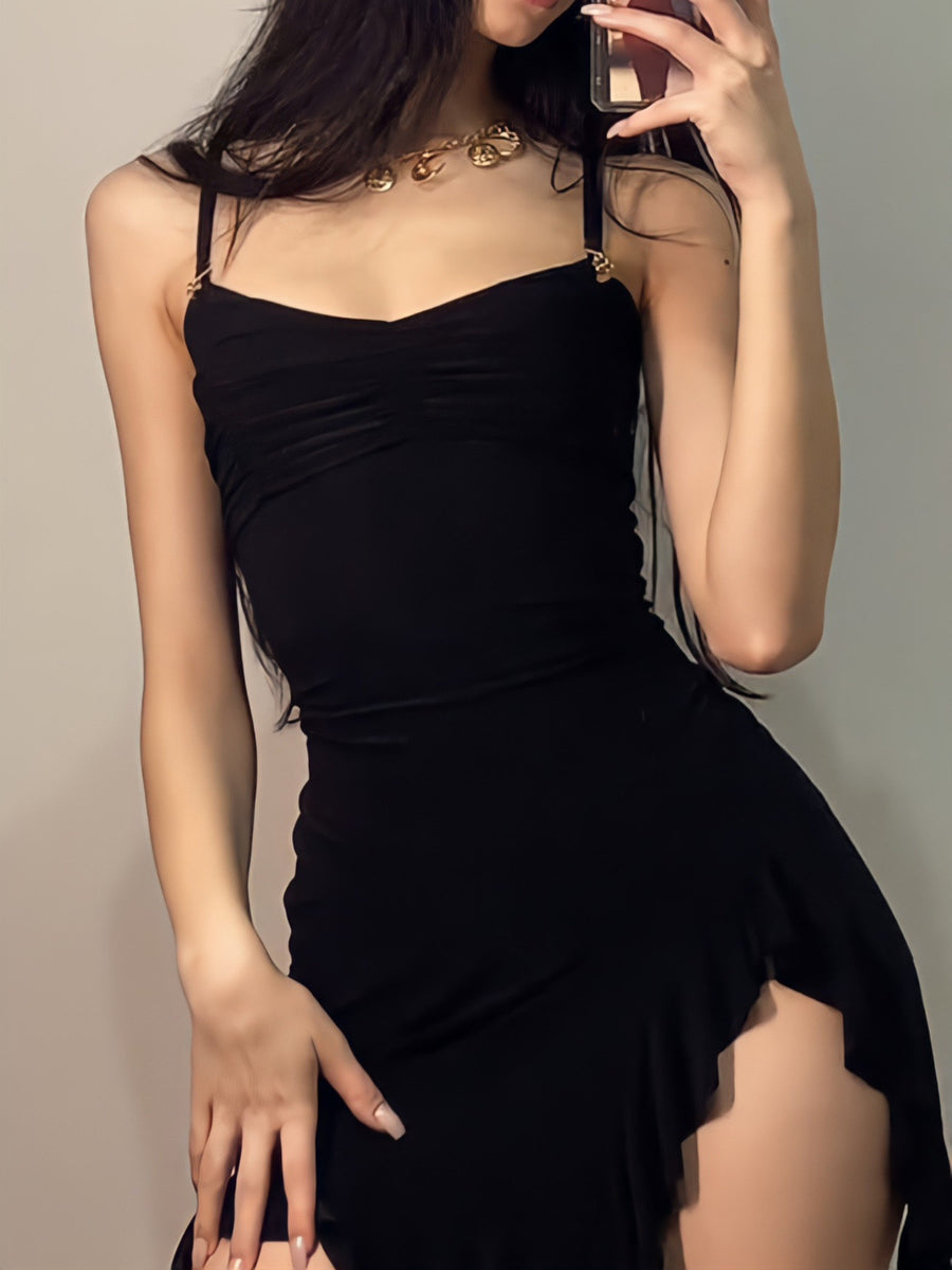 Black asymmetrical ruched mini dress with a high slit and gold hardware detail on straps.