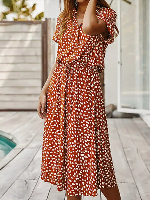 Midi dress in scarlet with white polka dots, short sleeves, collared neckline, and drawstring waist.