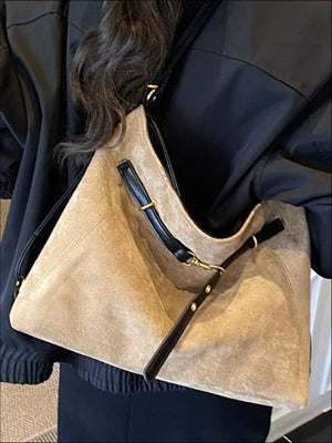 Khaki suede large tote bag with black leather trim and gold hardware details.