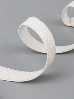 White elasticated buckle belt with textured fabric and leather detail.