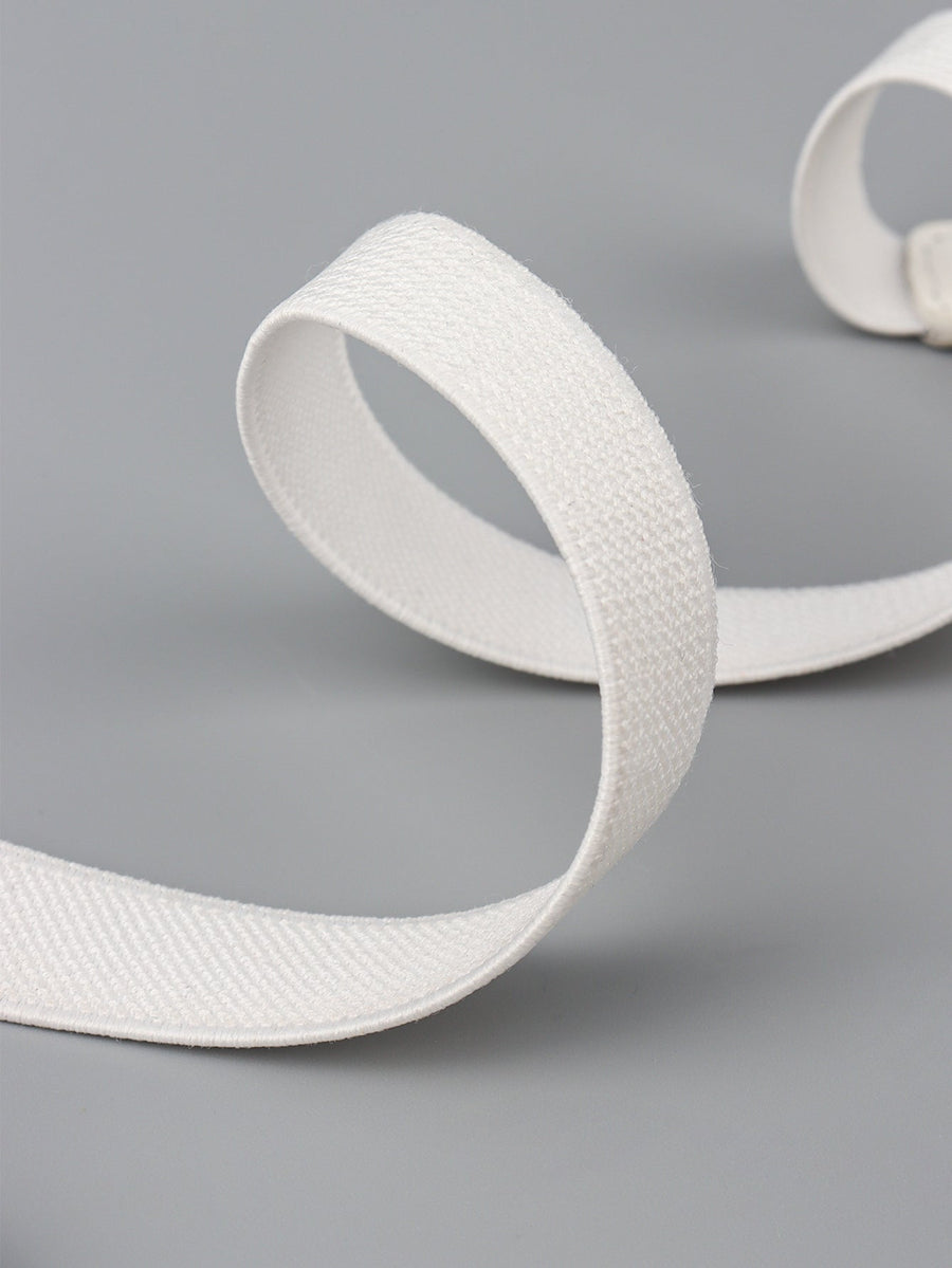 White elasticated buckle belt with textured fabric and leather detail.