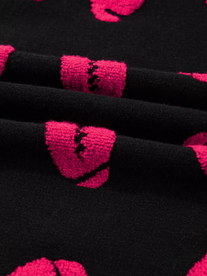 Black knit sweater with pink broken heart pattern