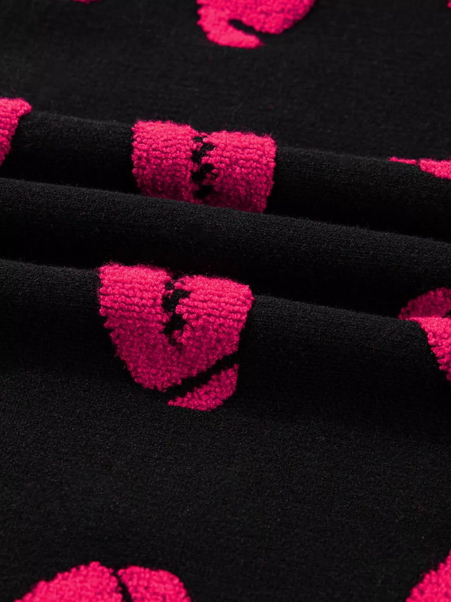Black knit sweater with pink broken heart pattern