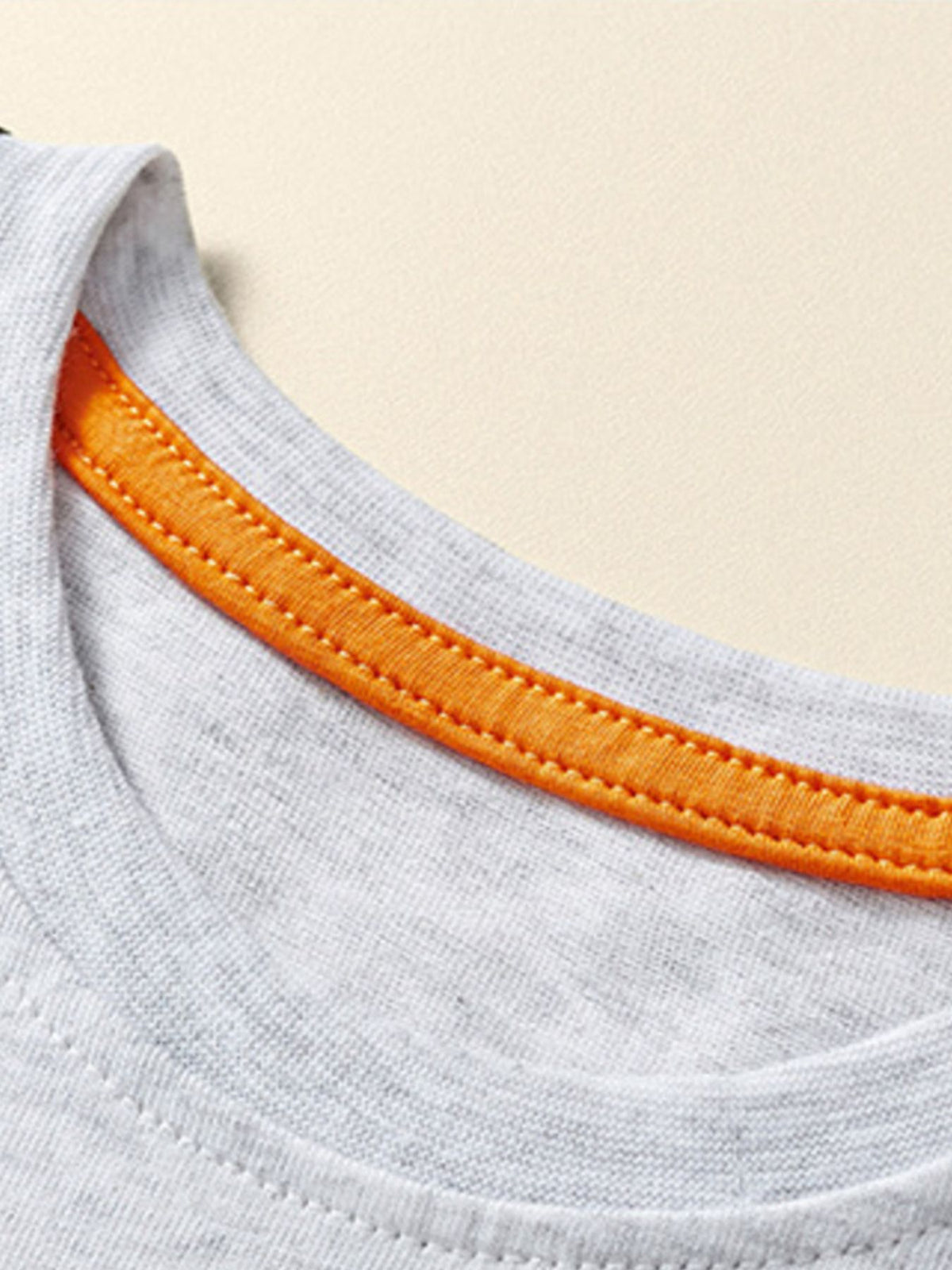Boys' grey cotton t-shirt with orange contrast stitching on the neckline.