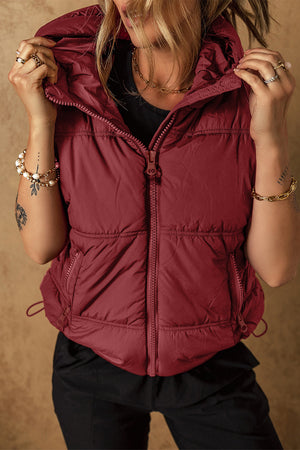Burgundy quilted hooded puffer vest with drawcord hem and zip pockets.