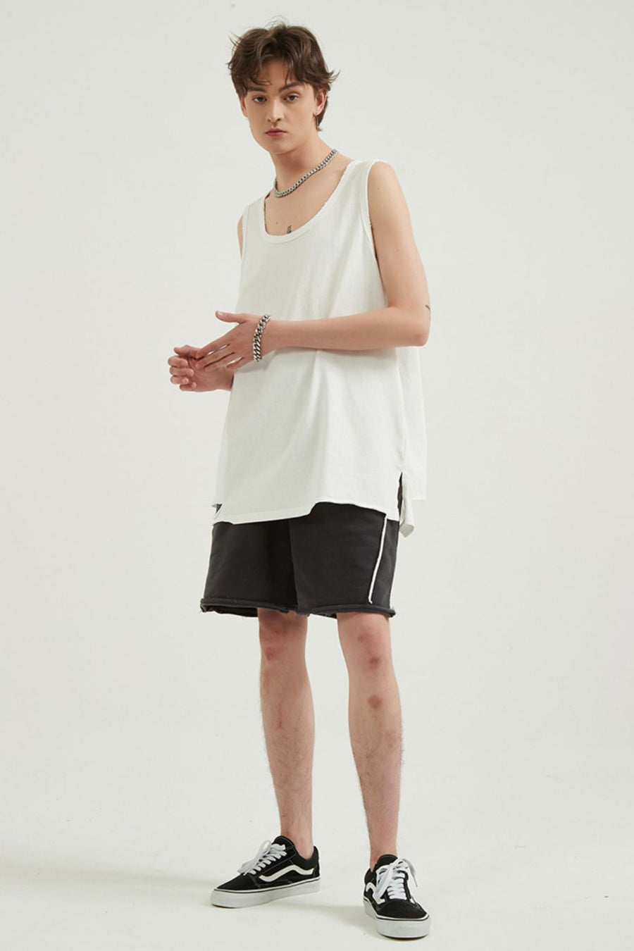 White sleeveless scoop neck tank top with black distressed shorts