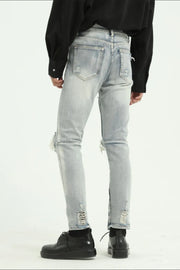 Light wash distressed skinny jeans with ankle zippers and ripped details.