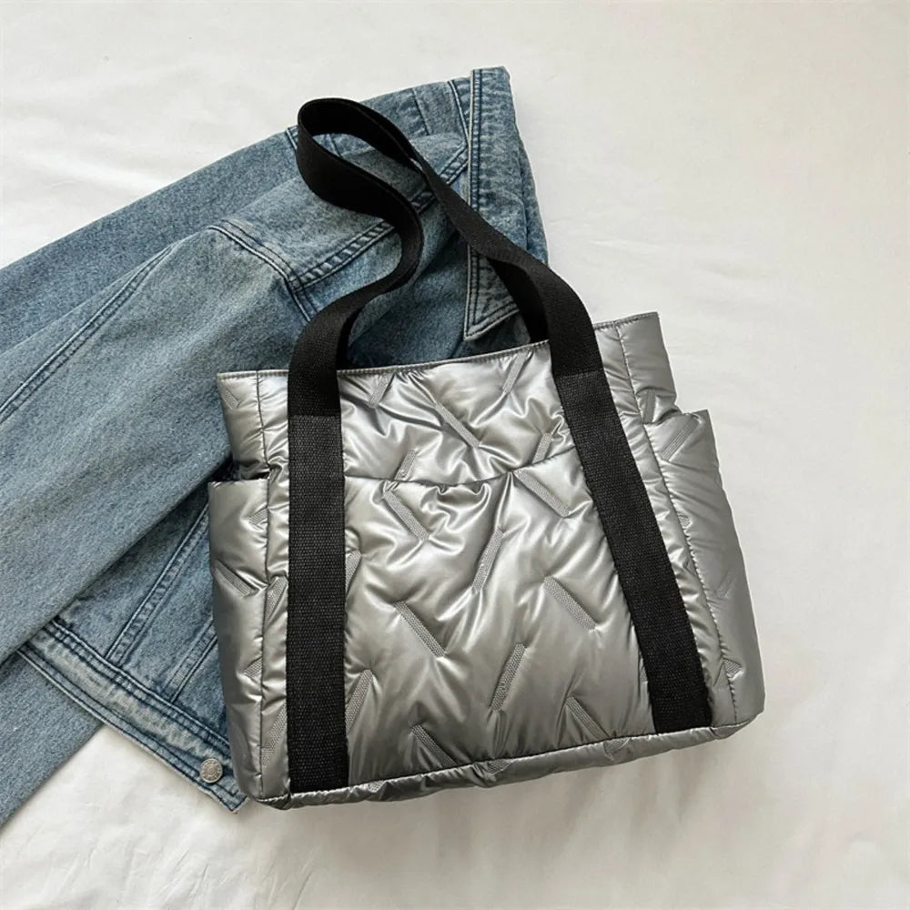 Padded silver nylon tote bag with exterior pockets and black straps