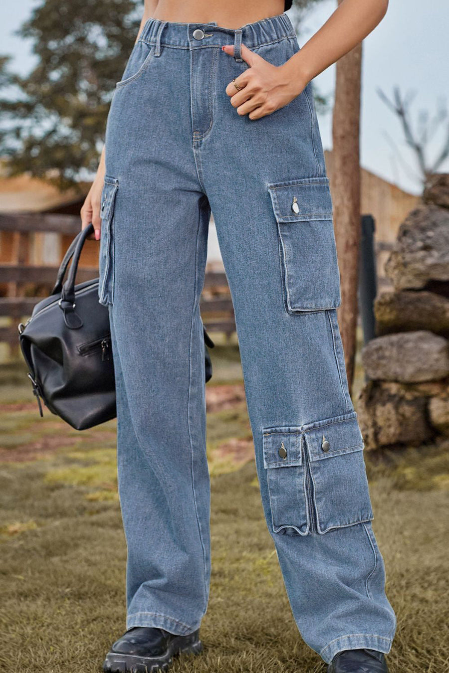 Light wash denim cargo pants with relaxed wide leg and multiple utility pockets.