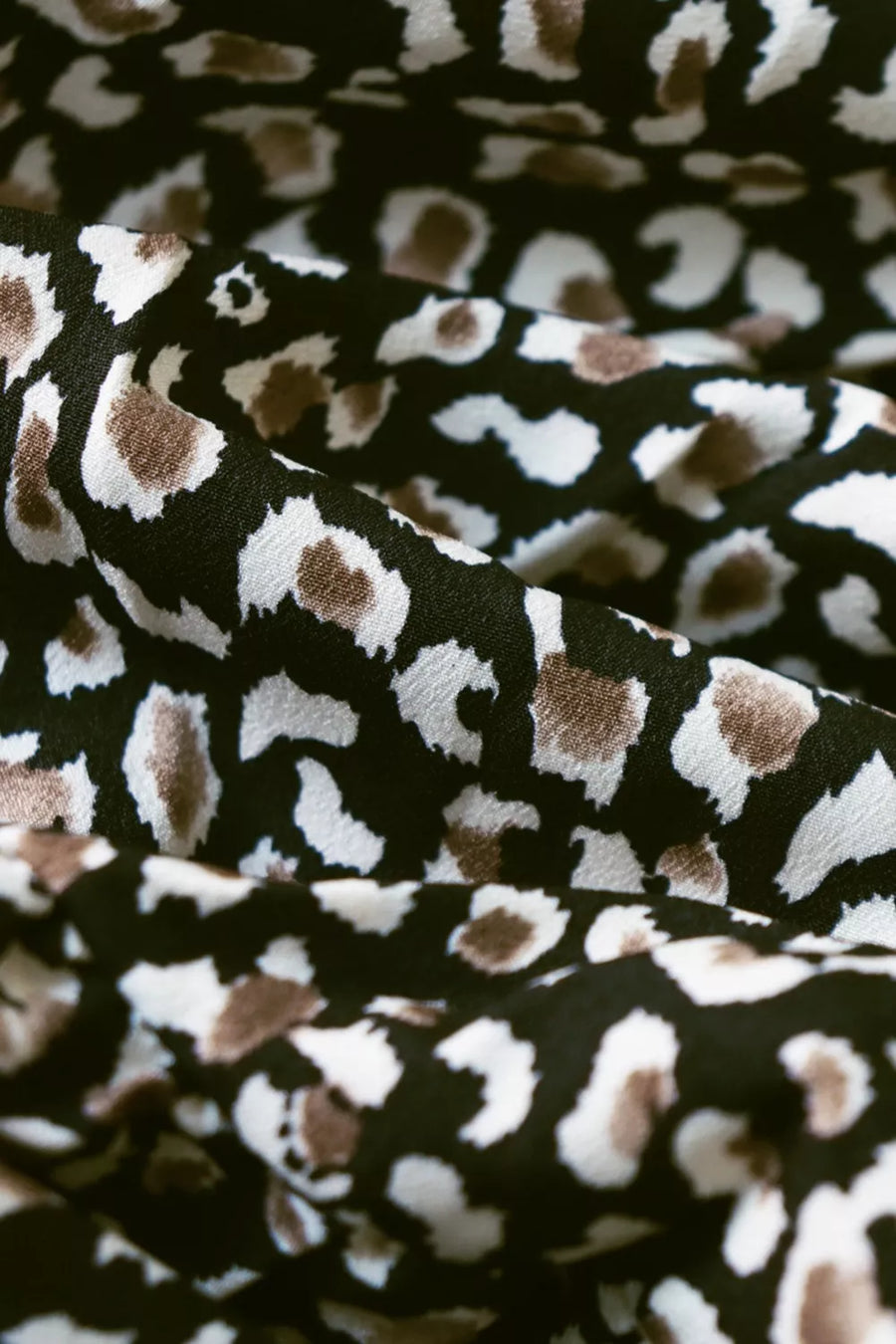 Chic midi dress fabric with black, white, and brown animal print and balloon sleeves.