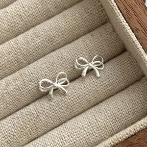 earrings in silver featuring bow detail and fitted fit