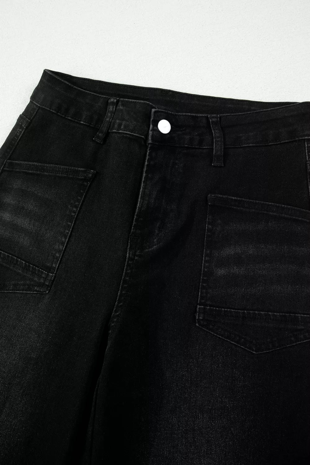 Black high-waisted cropped jeans with a raw hem and utility pockets.