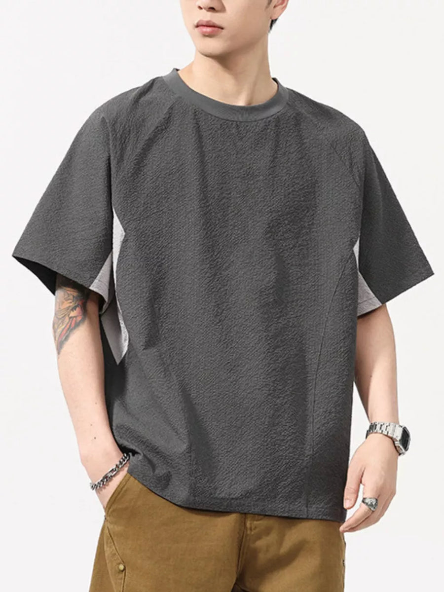 Men's dark gray textured t-shirt with contrast panels and crew neck.