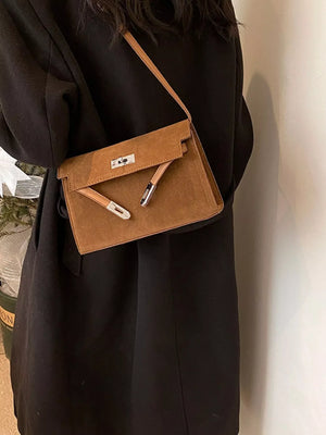 Elegant buckle shoulder bag in coffee color suede with silver hardware.