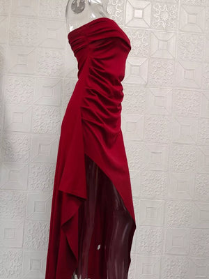 Burgundy ruched strapless maxi dress with a high slit and flowing skirt.