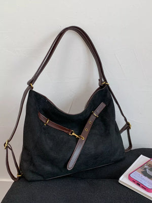 Black suede hobo bag with adjustable strap and dark brown leather trim.