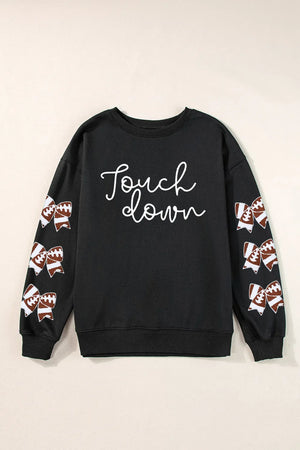 Black sweatshirt with white script "Touch down" and football-themed bow embellishments on sleeves.