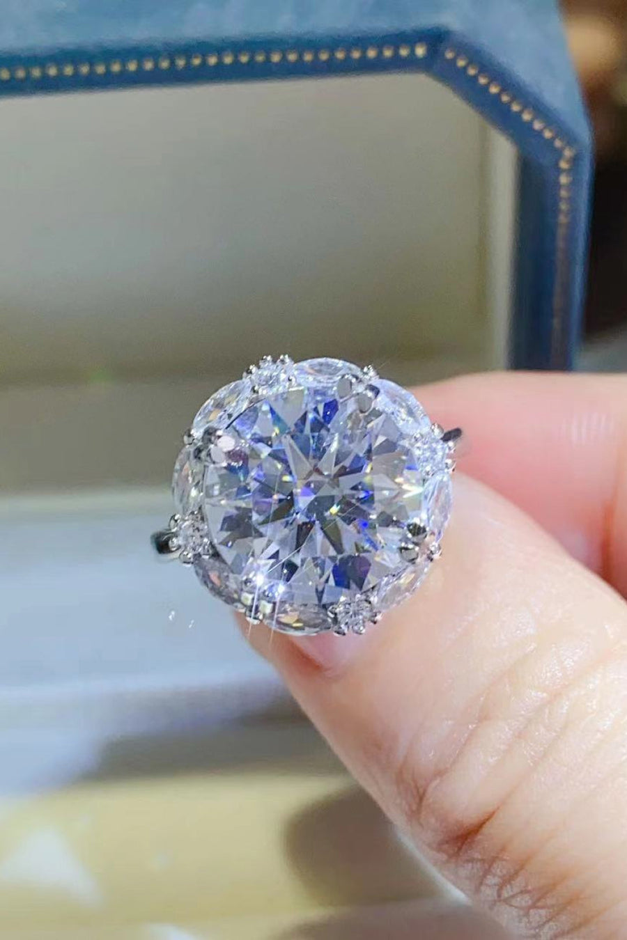 Silver moissanite halo statement ring with large round-cut center stone.