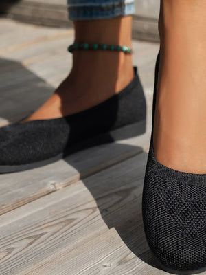 Black textured knit ballet flats with a round toe and subtle sole.